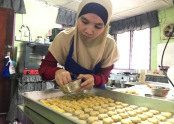 NOR Liyana Abdullah tekun menyiapkan tempahan biskut raya di rumahnya di Taman Wangi, Gua Musang, Kelantan. - UTUSAN/AIMUNI TUAN LAH