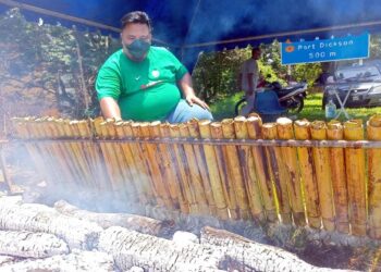 MOHAMMAD SAYUTI Zakaria membakar lemang untuk dijual kepada orang ramai yang singgah di gerainya di Masjid Tanah, Melaka. - UTUSAN/MUHAMMAD SHAHIZAM TAZALI