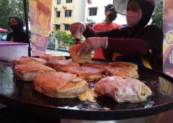 PEMBANTU gerai, Saadiah Mustapha memasak martabak rendang daging di Bazar Ramadan Kelana Jaya, Petaling Jaya, Selangor. - UTUSAN/MOHAMAD NAUFAL MOHAMAD IDRIS