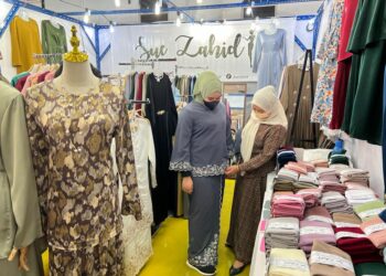 NOOR Suriani Zahid (kanan) membantu pelanggan di gerai miliknya di bazar raya Pusat Dagangan Terengganu (TTC) di Kuala Terengganu.