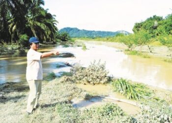 ABDUL Rahman Mohd. Redza menunjukkan lokasi air sungai yang  naik secara mendadak sekali gus menyebabkan beberapa lokasi di sekitar Linggi termasuk Darul Widad dinaiki air banjir. - UTUSAN/ZAKKINA WATI AHMAD TARMIZI