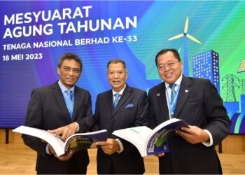 ABDUL Razak Abdul Majid (tengah), Baharin Din (kanan) dan Ketua Pegawai Kewangan TNB, Nazmi Othman melihat Buku Laporan Tahunan TNB di Mesyuarat Agung Tahunan TNB ke-33, di Kuala Lumpur, semalam.