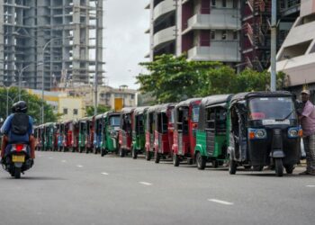 PEMANDU tiga roda beratur di sepanjang jalan untuk membeli petrol dari sebuah stesen minyak di Colombo. - AFP    