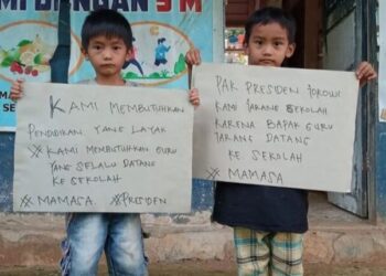 IMEJ yang menunjukkan dua murid memegang poster meminta Jokowi membantu mereka mendapatkan pendidikan sewajarnya di Mamasa. - AGENSI