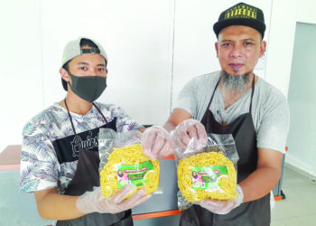 NURUL Hadi Ali (kanan) bersama anaknya Nurnajmuddin yang mengendalikan premis memproses mi kuning ‘Produk Ibu Aira’ di Taman Sri Saujana, Kota Tinggi.