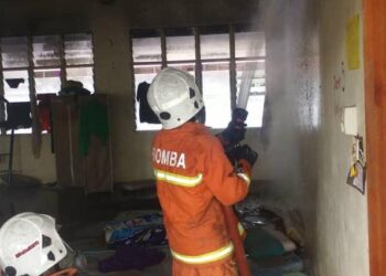 ANGGOTA bomba memadam kebakaran di bilik suis asrama SMK Tongod di Kinabatangan semalam.-IHSAN BOMBA