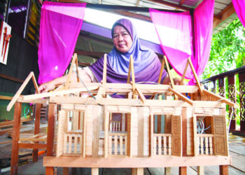 NORMA Che Noor bersama replika rumah yang dihasilkannya di rumahnya Kampung Warna Warni, Seberang Ramai, Kuala Perlis. - UTUSAN/IZLIZAN OTHMAN