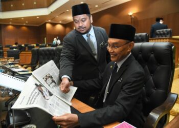 MOHD. Shukri Ramli (kanan) bersama Muhammad Azmir Azizan membaca wawancara di dalam akhbar Utusan Malaysia sempena 100 hari pemerintahan kerajaan PN di Kompleks DUN, Kangar, Perlis hari ini.-UTUSAN/IZLIZAN OTHMAN