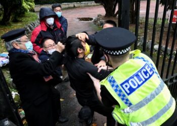 POLIS cuba meleraikan pergaduhan antara penunjuk perasaan dan pekerja konsulat China di hadapan bangunan konsulat di Manchester . - AFP