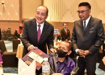 HAJIJI Noor (kiri) menyampaikan sijil penghargaan kepada Harun Udin, salah seorang pesara perkhidmatan awam negeri Sabah di Kota Kinabalu hari ini.