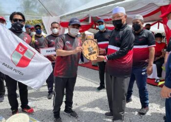 AHMAD Yakub (kanan) menyampaikan hadiah kepada ketua kontinjen Pasir Puteh, Ahmad Adlee Yasin dalam Karnival Sukan Antara Jajahan di Pantai Bisikan Bayu, Semerak, Pasir Puteh. - UTUSAN/TOREK SULONG.