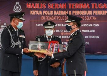 CHA Hoong Fong (kanan)  menerima tongkat kuasa sebagai simbolik pelantikan Ketua Polis Daerah Klang Selatan yang baharu daripada Shamsul Amar Ramli sambil disaksikan Arjunaidi (tengah) di IPD Klang Selatan di Klang, Selangor hari ini.