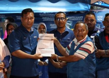 MASAAD Mansur (kanan) menyerahkan borang menyertai  Bersatu kepada Roslan Md. Sam yang disaksikan Zainol Fadzi Paharuddin  (tengah) di Durian Sebatang, Teluk Intan semalam. - UTUSAN