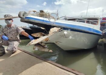 HASHIM MAT ZAIN menunjukkan bahagian haluan bot penumpang mewah yang remuk selepas merempuh bot penguatkuasa Maritim Malaysia di perairan Pantai Kurung Tengar, Kuala Perlis semalam- UTUSAN/SYED AZLAN SAYID HIZAR