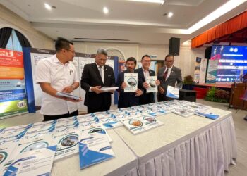 MOHD. UZIR MAHIDIN (tengah) melihat buku Statistik Subnasional Parlimen dan DUN selepas menyampaikan taklimat pada Penemuan Subnasional Parlimen dan DUN, Banci Penduduk & Perumahan Johor serta Prestasi Ekonomi Johor 2021 di Bangunan Sultan Ismail, Iskandar Puteri, Johor.