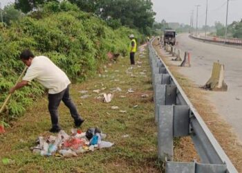 PETUGAS kebersihan Jabatan Kerja Raya (JKR) membersihkan sampah di laluan selepas jalan pintasan masuk ke Lingkaran Tengah Utama (LTU), Jalan Lipis - Merapoh berdekatan Kechau Tui di Lipis kelmarin.