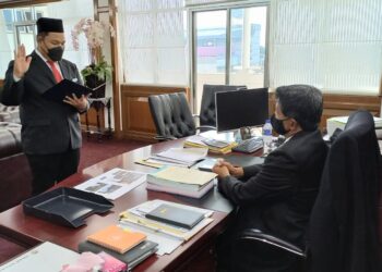 ABDUL RAFI MU'IZ Omar mengangkat sumpah jawatan di hadapan Zainal Abu di Pejabat MBMB, Melaka. - UTUSAN/AMRAN MULUP