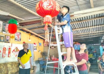 PENDUDUK berketurunan Cina memasang tanglung sempena sambutan Tahun Baharu Cina di Kampung Batu Balai, Jabi, Besut, Terengganu. - UTUSAN/KAMALIZA KAMARUDDIN