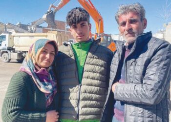 Taha Erdem, 17, (tengah) bersama ibunya, Zeliha Erdem dan bapa, Ali Erdem bergambar di hadapan bangunan yang musnah di Adıyaman, Jumaat lalu. -AP