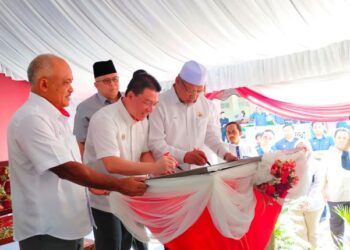 NGA Kor Ming (dua kiri) bersama Ahmad Yakob (kanan) menurunkan tandatangan sebagai gimik perasmian Pasar Tok Kenali di Kubang Kerian, Kota Bharu, Kelantan. - UTUSAN/YATIMIN ABDULLAH