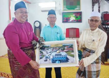 GUNTOR Tobeng (kiri) menyerahkan gambar pemasangan sistem tenaga solar di Masjid Al-Islah, Permatang Tok Mahat, Nibong Tebal, Pulau Pinang kepada Wan Salim Wan Mohd. Noor sebagai simbolik sambil diperhatikan oleh Ahmad Zakiyuddin Abdul Rahman.