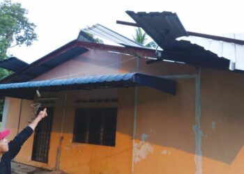 KAMAL Sairi menunjukkan atap zink bumbung rumahnya yang jatuh dipikul ribut dan angin kencang di Kampung Melayu Raya, Segamat, Johor.