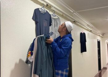 JEMAAH haji lelaki memasang tali untuk dijadikan tempat menyidai pakaian di ruangan kaki lima hotel. – IHSAN NADIAH NOORDIN