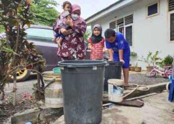 NURUL Fatihah Ibrahim bersama anak-anaknya menunjukkan bekalan air yang disimpan di rumah mereka di Kampung Paya Panji, Kota Bharu, Kelantan, semalam. - FOTO/YATIMIN ABDULLAH