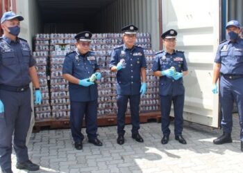 CHEONG Yu Min (tengah) menujukkan rampasan minuman keras yang diseludup masuk ke Sabah di Pelabuhan Sepanggar, Kota Kinabalu hari ini.