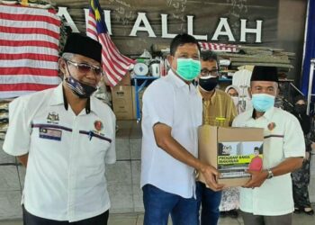ISA Abd. Salam (kanan) menerima sumbangan bakul makanan yang diserahkan Mohamad Ali Mohamad (tengah) dalam majlis penyampaian di Baitul Tariq, Klebang Permai, Melaka. - UTUSAN/AMRAN MULUP