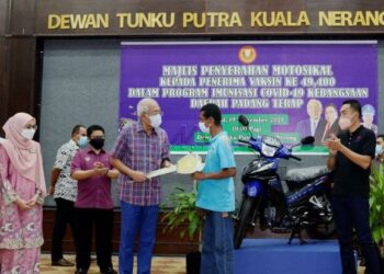 MAHDZIR Khalid menyerahkan replika kunci motosikal kepada Mohd. Isham Md. Isa di Kuala Nerang, Padang Terap hari ini. - UTUSAN/MOHD. RAFIE AZIMI