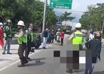 POLIS membantu mengangkat mangsa kemalangan maut melibatkan sepasang suami isteri di timur Balikpapan kelmarin.