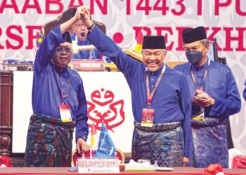 AHMAD Zahid Hamidi (tengah) menjulang tangan Ismail Sabri Yaakob (kiri) ketika Perhimpunan Agung UMNO (PAU) 2021 yang berlangsung di Dewan Merdeka, Pusat Dagangan Dunia Kuala Lumpur  (WTCKL) pada 19 Mac lalu. – UTUSAN/MUHAMAD IQBAL ROSLI