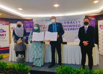ROZIAH Mohd. Janor (dua kiri) dan Mazlan Abd. Ghaffar (dua kanan) menunjukkan MoU yang ditandatangani kedua-dua universiti di UiTM, Shah Alam, Selangor hari ini.