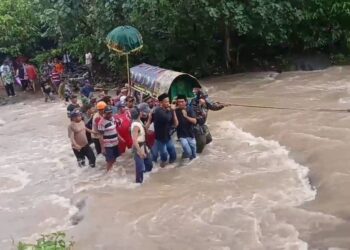 TANGKAP layar video menunjukkan orang ramai mengusung keranda sambil menyeberangi sungai di Lampung, Indonesia. - AGENSI