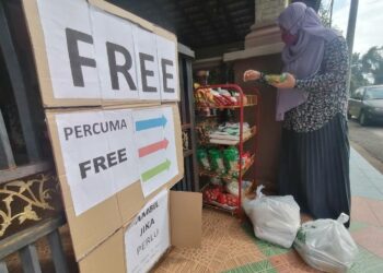 AZRA Abdullah menyusun barangan keperluan di rak 'bank makanan' di depan rumahnya di Taman Balok Permai, Kuantan, Pahang. -
UTUSAN/KHAIRULMIZAN YAHYA