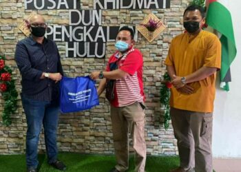 AZNEL Ibrahim (kiri) menyerahkan sumbangan barang makanan kepada wakil penduduk yang terjejas disebabkan PKPD di Pejabat Khidmat Masyarakat DUN Pengkalan Hulu, Perak, hari ini. - UTUSAN/NORLIA RAMLI