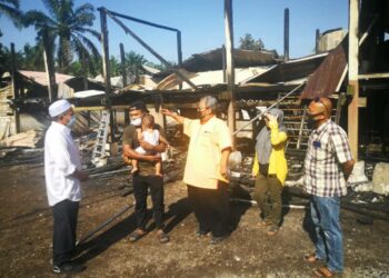 ZABBIR Ahmad (dua dari kiri)menunjukkan rumah tinggalan arwah bapanya yang berusia lebih 90 tahun kepada Jahaya Ibrahim (kiri)  yang musnah dalam kebakaran dekat Jalan Ros, Kampung Batu 7 di Ijok, Selangor.