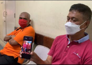 AHMAD Kamal Mohd Isa ( kanan) menunjukkan gambar anaknya, Asna Hazim dalam telefon bimbitnya ketika ditemui di Unit Forensik HSM  di Lumut hari ini. - UTUSAN/SHAMSUL KAMAL AMARUDIN