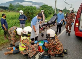 ANGGOTA bomba memberi rawatan awal kepada kakitangan KKM yang cedera setelah kenderaan dipandunya terbabas di Jalan Jelapang-Taman Meru, Ipoh, Perak, hari ini. - IHSAN JBPM PERAK