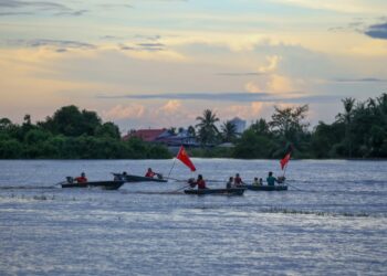 BERAPA penduduk membawa bot di dalam petak sawah yang dipenuhi air dalam kejadian banjir di Kampung Kandai, Mukim Tajar, Alor Setar, Kedah, hari ini. - UTUSAN/ SHAHIR NOORDIN