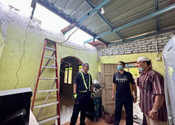TUANKU Syed Faizuddin Putra Jamalullail (kiri) menyantuni empat buah rumah asnaf termasuk seorang mangsa dalam kejadian ribut di Kangar, Perlis semalam.- UTUSAN