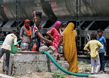 GOLONGAN wanita mengisi bekalan air dalam bekas sebagai persiapan menghadapi cuaca panas luar biasa di Pali, India. - AFP