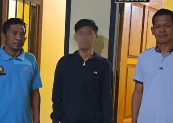 SUSPEK berusia 27 tahun (tengah) ditahan di Balai Polis Tana Tidung kelmarin.-AGENSI