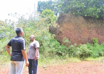 JEFRI Salim (kiri) melihat lubang atau 'kawah besar' kesan aktiviti perlombongan bauksit berhampiran rumah penduduk yang terbiar sejak tujuh lalu di Felda Bukit Goh di Kuantan, Pahang. - UTUSAN/SHAIKH AHMAD RAZIF