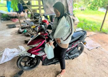 NORSIAH Khalid berulang alik dua ke tiga kali sehari bagi mengambil bekalan air di Felda Mata Ayer, Padang Besar, Perlis, semalam.-
UTUSAN/ASYRAF MUHAMMAD