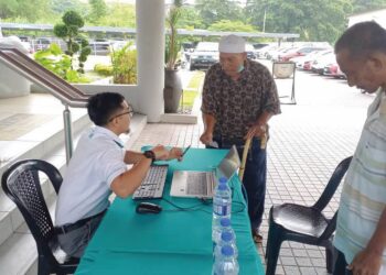 KAKITANGAN BSN membantu warga emas menyemak status bantuan STR Fasa Tiga di Jalan Munsyi Abdullah, Banda Hilir, Melaka. - UTUSAN/AMRAN MULUP