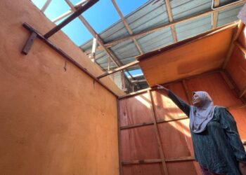 NORZILAH Abdul Rahman menunjukan keadaan rumahnya tanpa atap selepas diterbangkan angin dalam kejadian ribut di Kampung Permatang Rambai, Pasir Puteh, Kelantan, hari ini. UTUSAN/TOREK SULONG