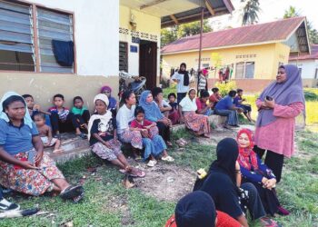 IDA Terang (berdiri kanan) bersama masyarakat Orang Asli di Kampung Kuala Lah, Gua Musang, Kelantan. - UTUSAN/AIMUNI TUAN LAH