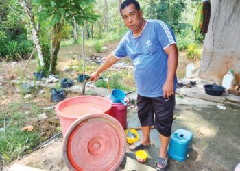 HASRAN Shahidan menunjukkan paip tidak mengeluarkan air untuk menyimpan bagi bekalan memasak, membasuh dan mandi di rumah Jalan Kelompok, Kampung Som di Jerantut, Pahang. - UTUSAN/HARIS FADILAH AHMAD